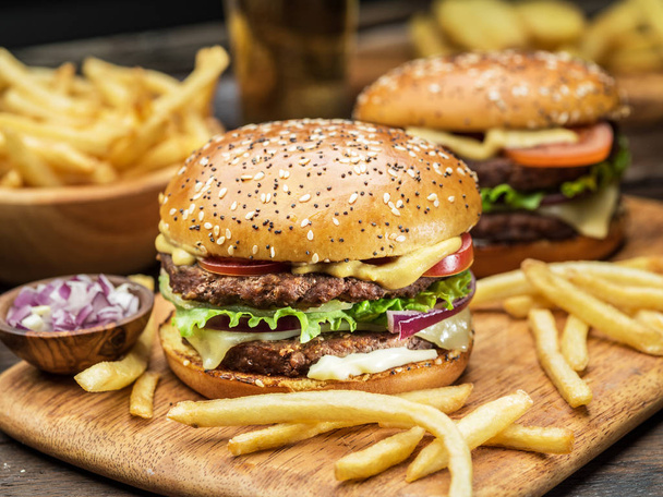 Hamburgers and French fries on the wooden tray. - Foto, immagini