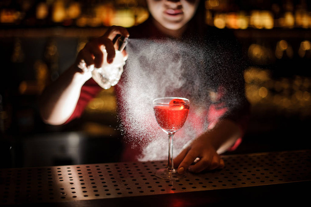 Female bartender sprinkling a cocktail glass filled with tasty Aperol syringe summer cocktail with a peated whisky - Foto, Bild