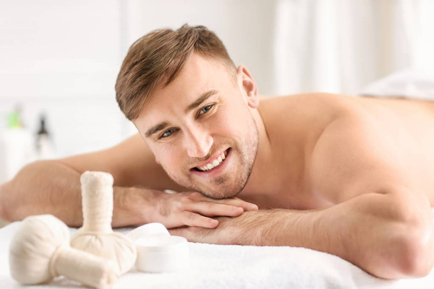 Young man relaxing in spa salon - Foto, imagen