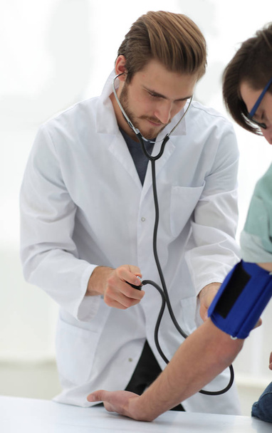 Physician measuring blood pressure to make a diagnosis - Foto, Imagen