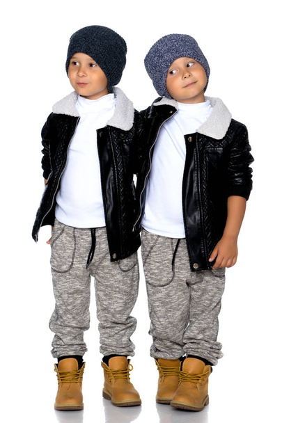 Two little boys in black jackets and hats. - Foto, afbeelding