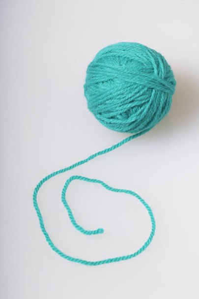 Tangle of thread for knitting emerald color on a white background. - Fotó, kép