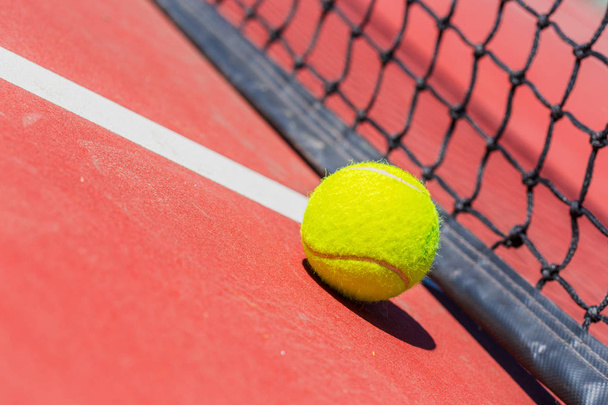 tennis ball on a tennis court with net - Фото, изображение