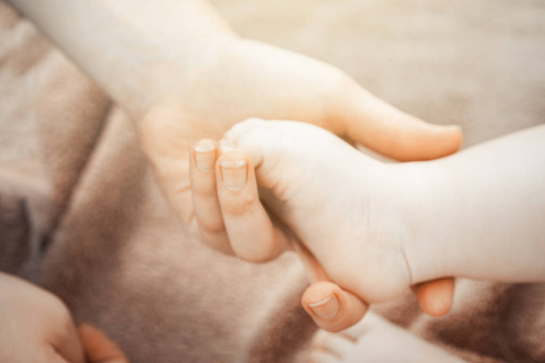 Baby feet in mother hands. Tiny newborn baby feet, concept of happy family. Fake color tone of phot - Fotoğraf, Görsel