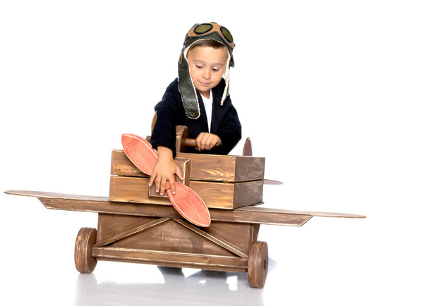 Little boy with a wooden plane. - Foto, afbeelding
