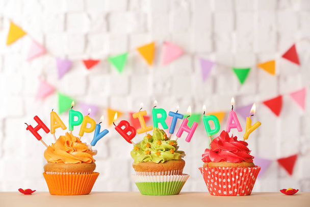 Birthday cupcakes with candles against blurred background - Φωτογραφία, εικόνα