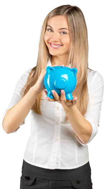 Mujer joven feliz con una caja de dinero aislada en blanco
 - Foto, Imagen