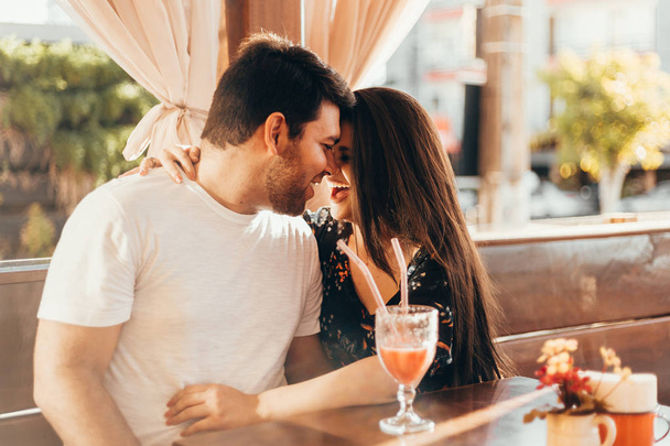 Młoda para zakochanych siedzi w restauracji, filiżance kolorowy napój, po rozmowie i czas spędzony ze sobą - Zdjęcie, obraz