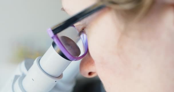 Female scientist looking through microscope - Video