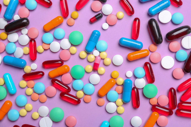 Different pills and capsules on color background - Foto, Imagem