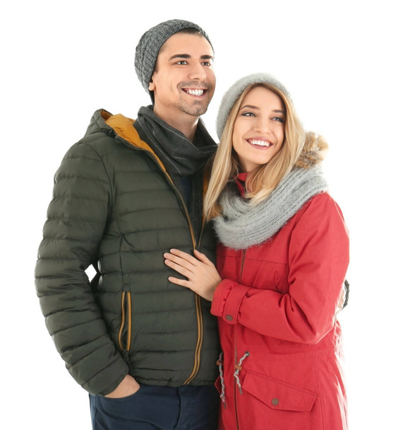 Jeune couple en vêtements chauds sur fond blanc. Prêt pour les vacances d'hiver
 - Photo, image
