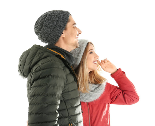 Young couple in warm clothing on white background. Ready for winter vacation - Fotoğraf, Görsel