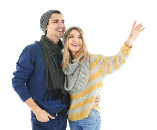 Young couple in warm clothing on white background. Ready for winter vacation - Фото, изображение