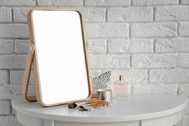 Elegantní zrcadlo a kosmetické výrobky na stole - Fotografie, Obrázek