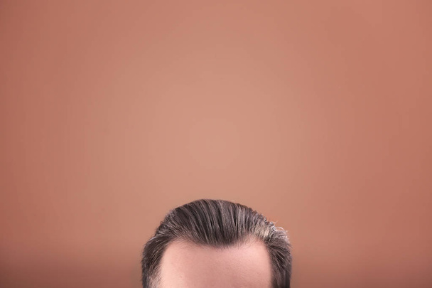 Young man with beautiful hair on color background, closeup - Fotó, kép