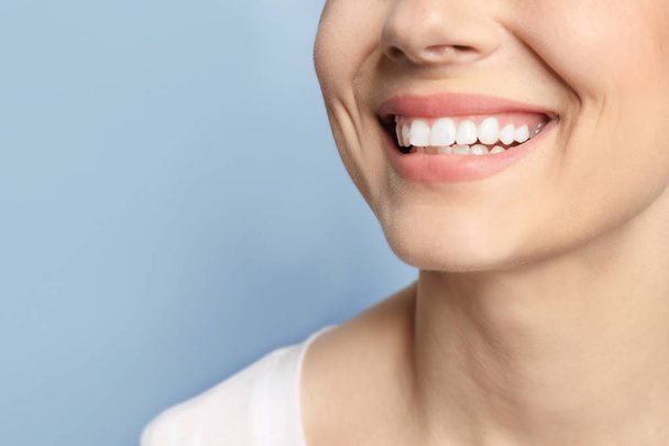 Young woman with beautiful smile on grey background. Teeth whitening - Photo, Image