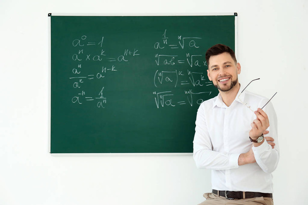 Portrait of male teacher near blackboard in classroom - Foto, imagen