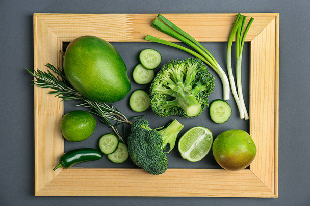 Different green vegetables and fruits in wooden frame, top view - Valokuva, kuva