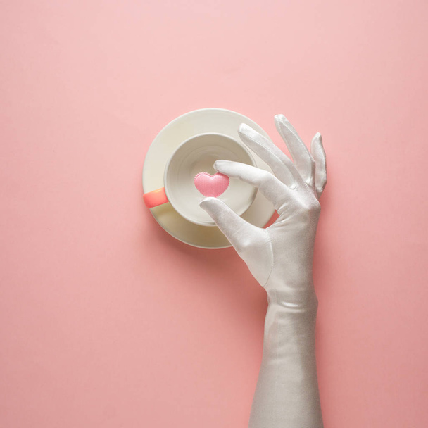 Creative concept photo of kitchenware with hand, painted plate with food on it on pink background. - Foto, Imagen
