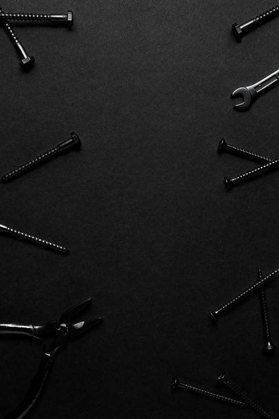 Creative concept photo of painted tools and nails on black background. - Fotoğraf, Görsel