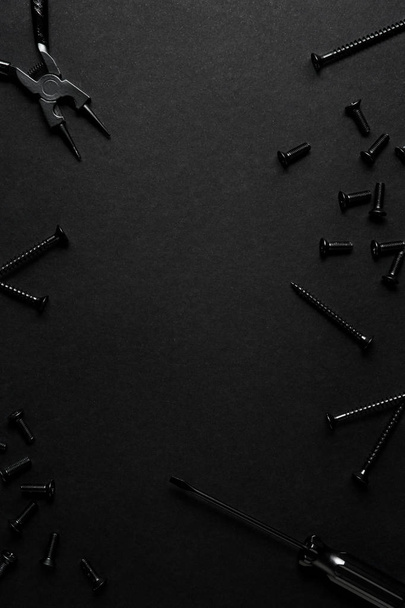 Creative concept photo of painted tools and nails on black background. - Foto, Bild