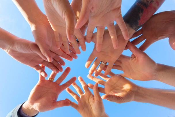friends stacking hands on sky background - Foto, Imagen