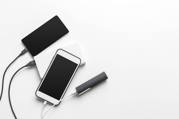 Smartphones rechargeant avec banque d'alimentation sur fond de table
 - Photo, image