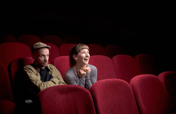 Young couple sitting at red movie theatre - Photo, Image