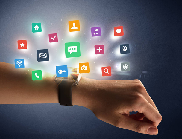 Mano femenina usando smartwatch con iconos de aplicaciones
 - Foto, imagen