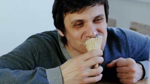 Closeup of young lousy man eats ice cream. - Кадри, відео