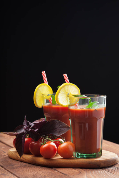Bloody mary cocktails served in glass with straws and lemons - Foto, Imagen