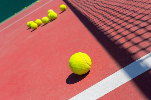 tennis balls on a tennis court with net - Foto, Bild