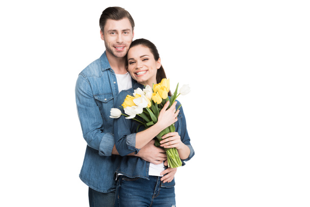 happy couple with bouquet of spring flowers, isolated on white - 写真・画像