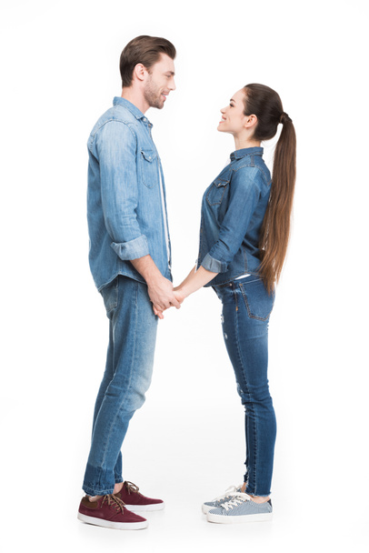 young couple holding hands and looking at each other, isolated on white - Foto, afbeelding