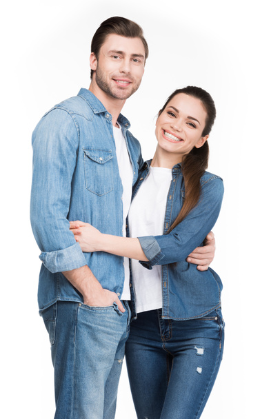 happy couple in jeans hugging and looking at camera, isolated on white - 写真・画像