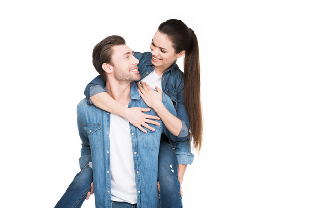 young man piggybacking girlfriend, isolated on white - Foto, afbeelding