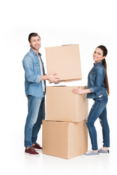 happy young couple moving with cardboard boxes, isolated on white - Foto, Imagem