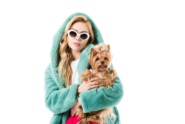 Blonde woman in fir coat hugging Yorkshire terrier isolated on white - Fotoğraf, Görsel