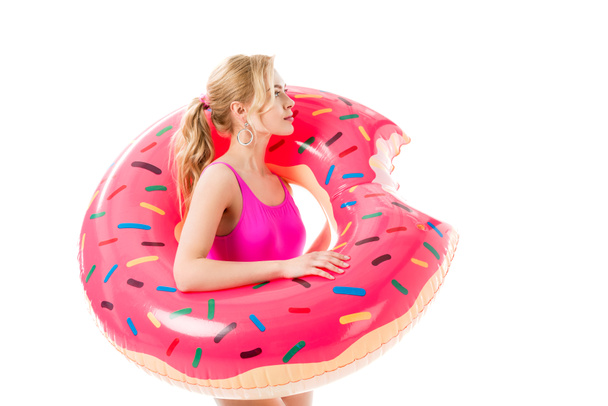 Blondine im rosa Badeanzug mit Donut-Schwimmring auf weißem Grund - Foto, Bild