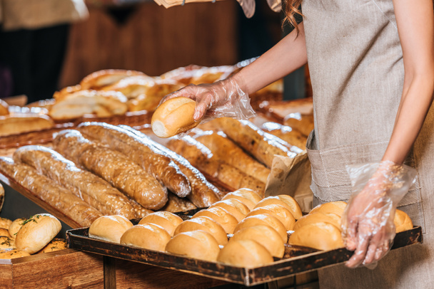częściowy widok Subiekt organizowanie loafs chleba w rynku zakupów - Zdjęcie, obraz