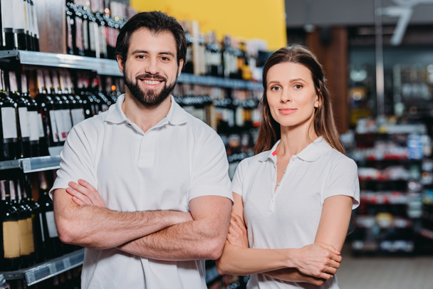 retrato de asistentes de tienda sonrientes con los brazos cruzados en el hipermercado
 - Foto, Imagen