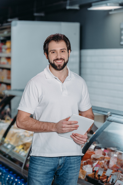 πορτρέτο του χαμογελώντας κατάστημα βοηθός με tablet σε υπεραγορά - Φωτογραφία, εικόνα