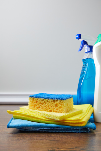 blue and yellow sponge, rags and bottles for spring cleaning - Foto, Imagen