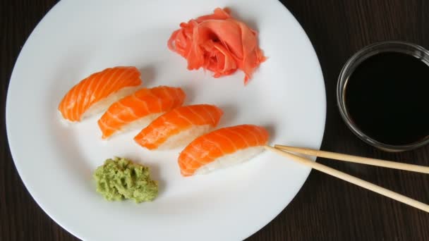Quattro grandi sushi con pezzo di salmone si trovano su un grande piatto piano. Macchina fotografica si muove a destra
 - Filmati, video