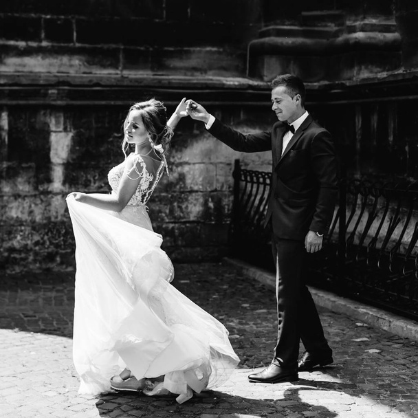 элегантный танец молодоженов у стены на черно-белом фото
 - Фото, изображение