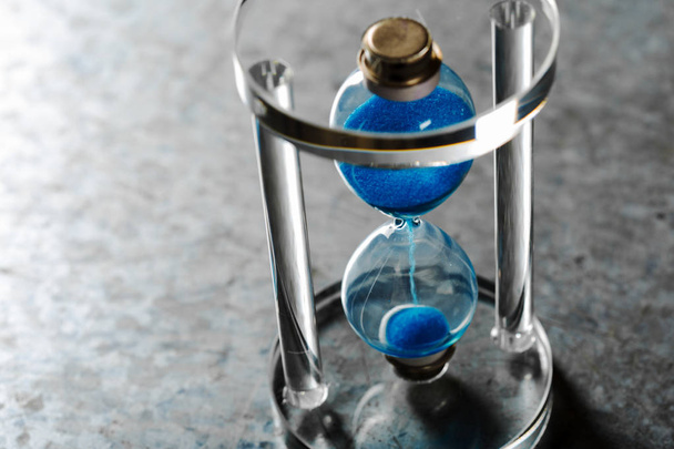 Time is passing. Blue hourglass close up - 写真・画像