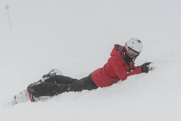 Сноубордист лежит на снегу, Уистлер, Британская Колумбия, Канада
 - Фото, изображение