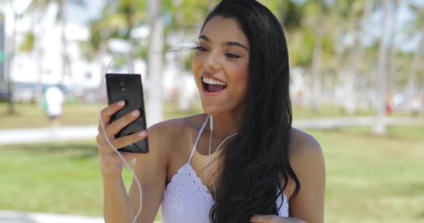 Mujer riendo hablando en línea en el parque
 - Imágenes, Vídeo