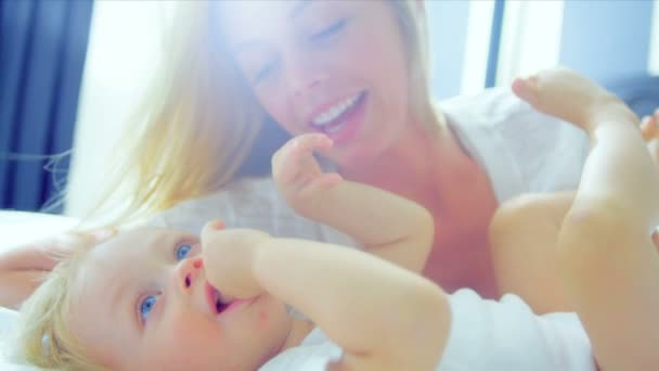 blonde Mutter hält kleines Kind im Schlafzimmer - Filmmaterial, Video
