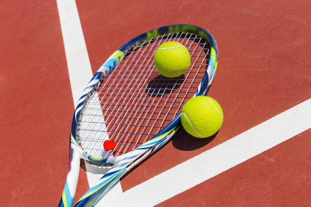 Tennis balls and racket on the grass court - Fotoğraf, Görsel
